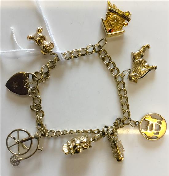 9ct gold curb-link charm bracelet with 5 gold and 2 plated charms(-)